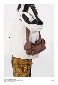 Brown canvas crossbody bag with adjustable wide strap shown in a casual streetwear outfit