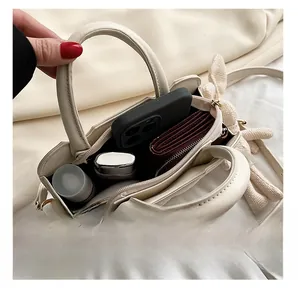 Internal view of cream crossbody bag showing three storage layers for phone and cosmetics