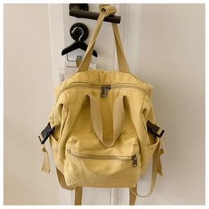Detail of yellow canvas backpack with adjustable straps and side safety buckle closure
