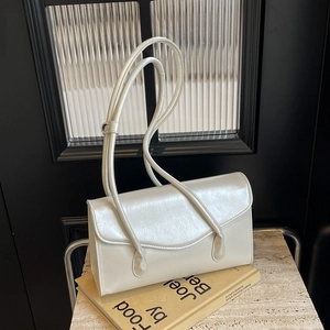 Chic cream white minimalist baguette underarm bag with elegant wavy flap and slim straps