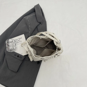 Chic white leather bucket bag with chain strap and spacious organized interior compartments