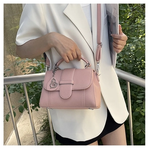 Pink lychee texture leather handbag featuring a silver swan charm and adjustable strap