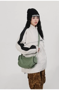 Detail of green washed canvas messenger bag featuring vintage texture and multi-pockets
