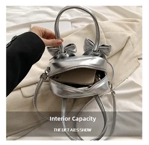 Top view of silver bow-knot bag showing spacious interior capacity and zipper detail