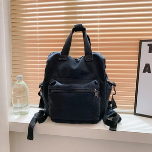 Minimalist black canvas backpack with large capacity and dual-handle design for travel