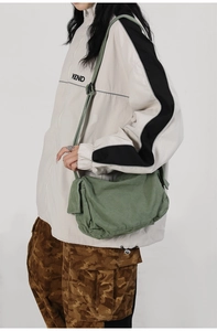 Grass green washed canvas messenger bag featuring a flap cover and side pockets