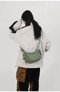 Army green canvas crossbody bag showing large capacity and casual street style on a model