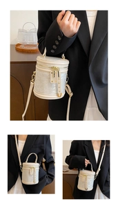 Detailed macro view of white floral jacquard fabric and gold rivet accents on the bucket bag