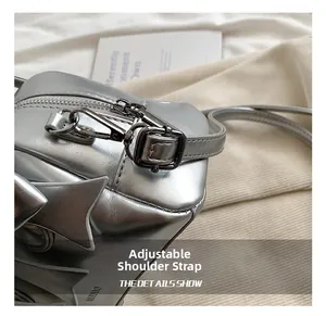 Close-up of adjustable metal buckle and zipper on silver metallic bow pillow bag