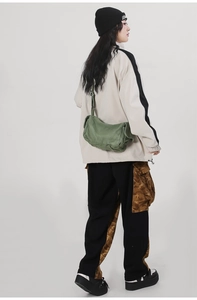 Olive green canvas crossbody bag styled with street fashion streetwear on a model
