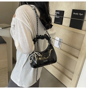 Détails du sac plissé noir brillant avec breloque nœud perlé et chaîne argentée