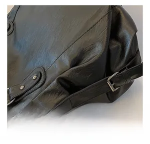 Close-up of durable metal hardware and textured black leather on a stylish tote bag