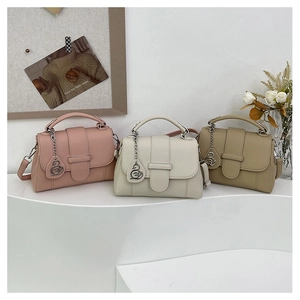 Detailed view of荔枝纹 textured handbags in pink, beige, and khaki with swan charms