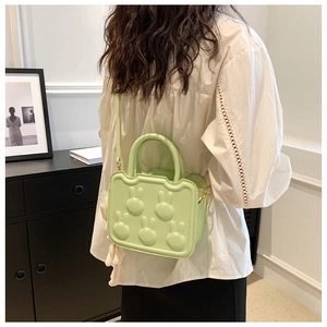 Detail of light green bag with 3D bunny patterns and plush charm accessory