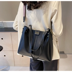 Détail du grand sac cabas en cuir noir avec surpiqûres blanches et bandoulière tissée