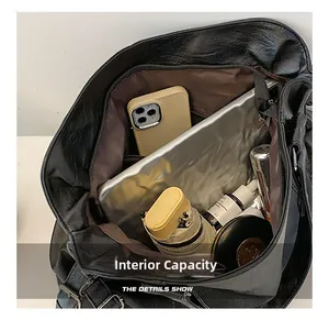 Detailed interior capacity showing large main compartment and zipper pocket of black tote bag