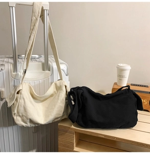 Detail of washed canvas crossbody bags with utility flap pockets in cream and black
