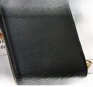 Close-up of black PU leather card holder with litchi texture and golden zipper detail
