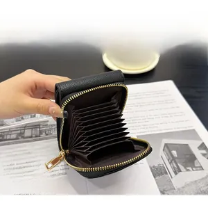 Detail of black litchi leather accordion card holder with gold zipper and multi-slots
