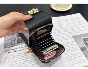 Detail of black lychee grain mini accordion wallet with gold hardware and card slots