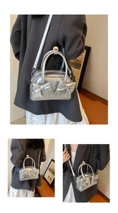 Close-up of silver bow pillow bag featuring shiny metallic PU and detachable strap