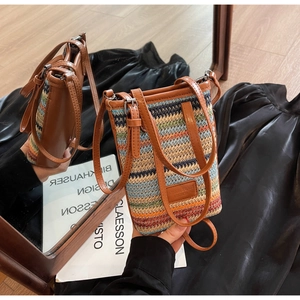Détail d'un petit sac seau tissé coloré avec finitions en cuir marron et bandoulière
