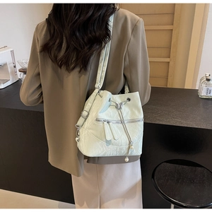 Detail der minzgrünen Beuteltasche mit silbernem Schmetterlingszug und Perlenanhängern
