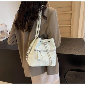 Detail der mintgrünen Beuteltasche mit Schmetterlingsschnalle und weißen Perlenanhängern