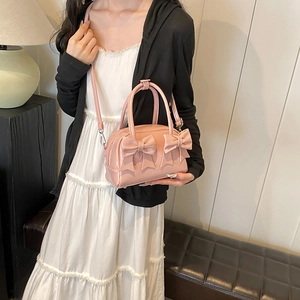 Pink bow-knot handbag in shiny PU leather with adjustable shoulder strap and top handles