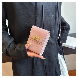 Detail of pink lychee leather card holder featuring a gold-tone lock and zipper closure