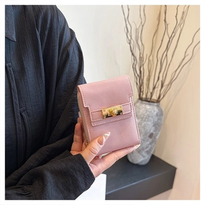 Close-up of pink mini clutch bag featuring lychee texture and gold twist lock closure