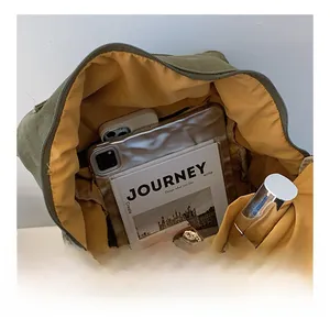 Vue détaillée de l'intérieur du sac à dos en toile avec doublure jaune et poches