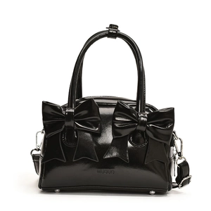 Glossy black bow-knot handbag with top handles and adjustable strap on white background