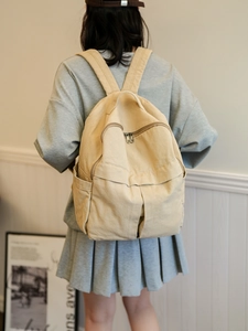 Vue arrière d'un mannequin portant le grand sac à dos en toile lavée kaki pour étudiantes
