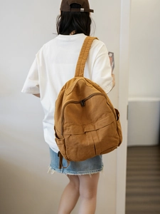 Vue détaillée du grand sac à dos en toile lavée marron porté par un mannequin en salle