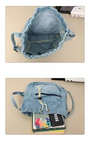 Detail view of washed denim bucket bag interior and zipped pocket with drawstring closure