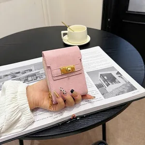 Pink cross-grain leather mini handbag with gold twist lock on a black coffee table