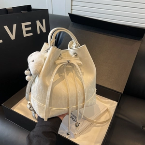 Minimalistische Marmor-Eimertasche in Weiß mit Kordelzug-Schleife und Plüschanhänger