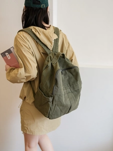 Vue latérale du sac à dos en toile vert olive sur mannequin montrant sa grande capacité