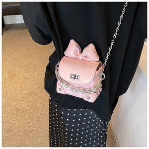 Roze mini crossbody tas met grote decoratieve strik en opvallende zilveren ketting