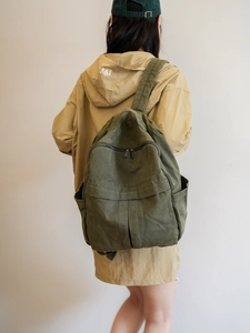 Détail du sac à dos en toile lavée vert armée montrant la grande capacité et le tissu texturé