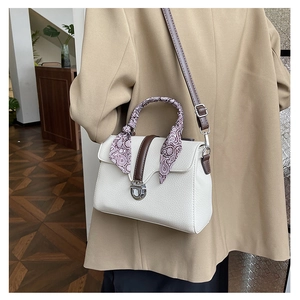 Detail of white lychee texture tote bag with vintage patterned scarf on handle