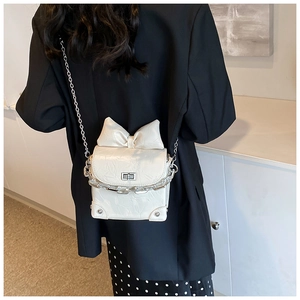 Mini white crossbody bag with bow detail and silver chain shown on model back