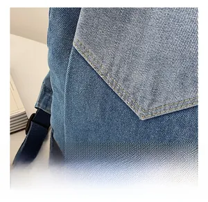 Detail view of premium light blue denim fabric texture and fine stitching on a backpack