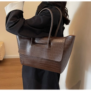 Model wearing a dark brown crocodile embossed tote bag with large capacity and retro style