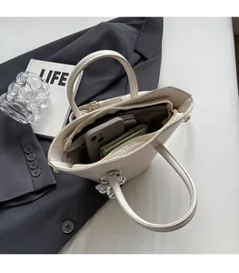 Interior view showing spacious storage for smartphone and wallet in a cream bucket bag
