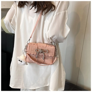 Détail sac bandoulière rose avec boucle nœud argentée et pendentif peluche blanc