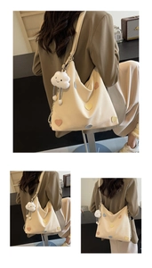 Detail of beige hobo bag with colorful heart patches and cloud plush charm