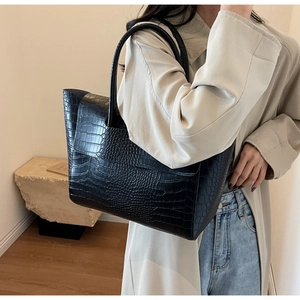 Close-up of black crocodile pattern tote bag with long double handles for daily commute