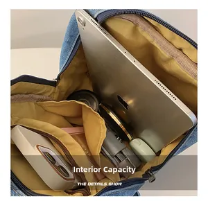 Detail view of denim backpack interior with yellow lining and spacious compartments